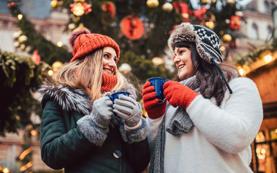 beste Freunde genießen Glühwein auf dem Weihnachtsmarkt